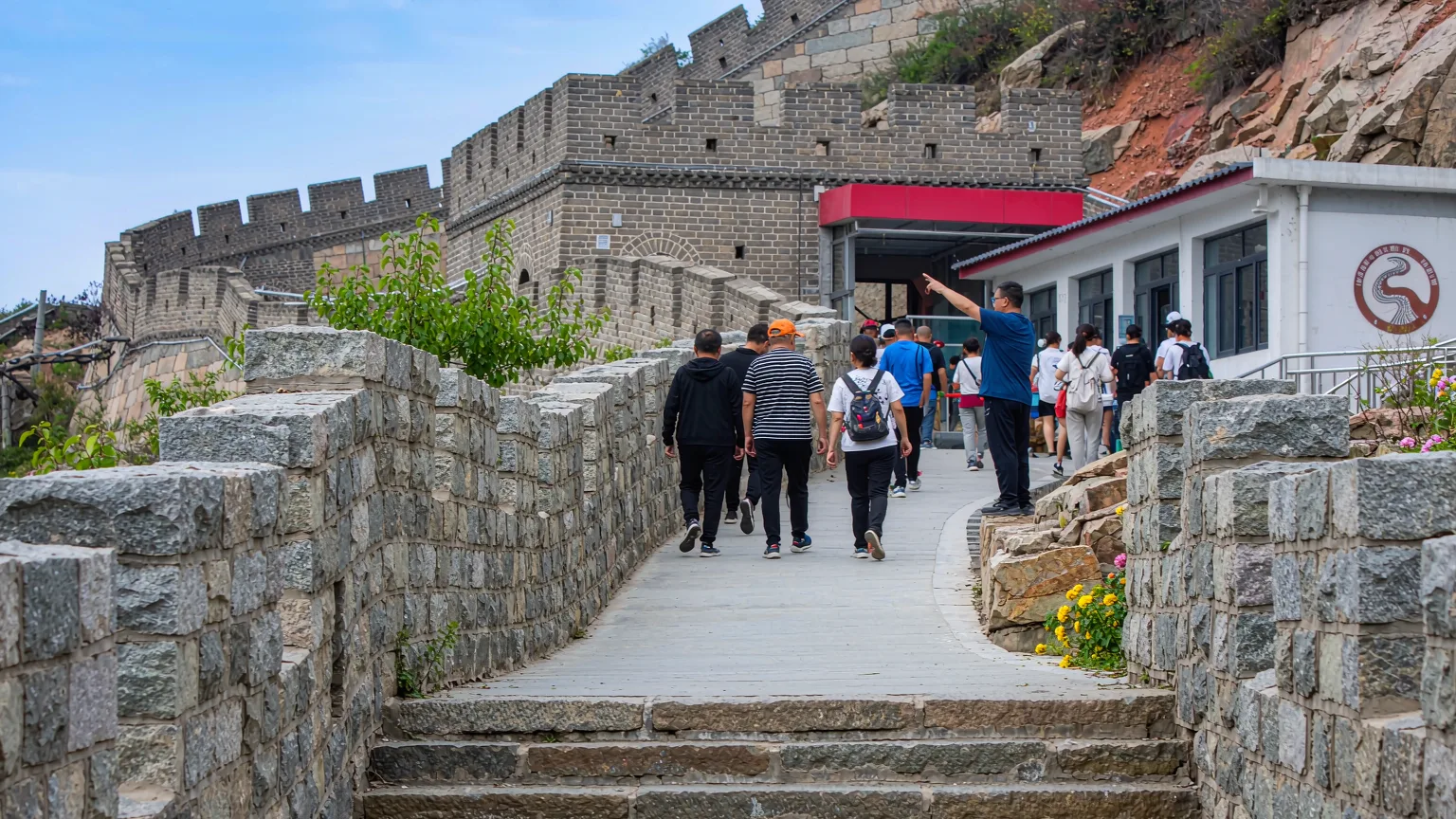 Visitors walking stone steps toward Badaling watchtower near cable car entrance