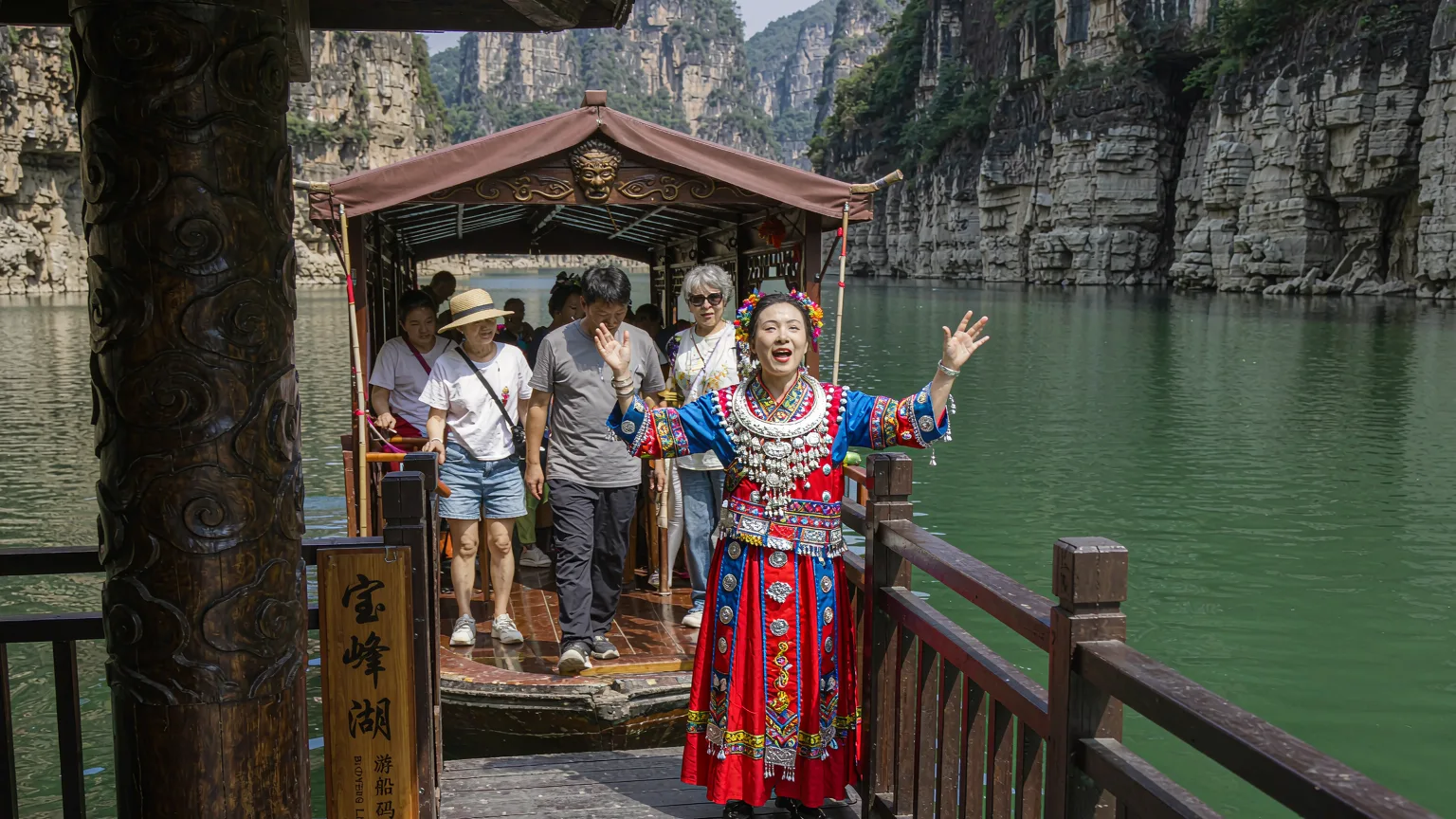 Tourists boarding a boat at Baofeng Lake with a Tujia singer aboard