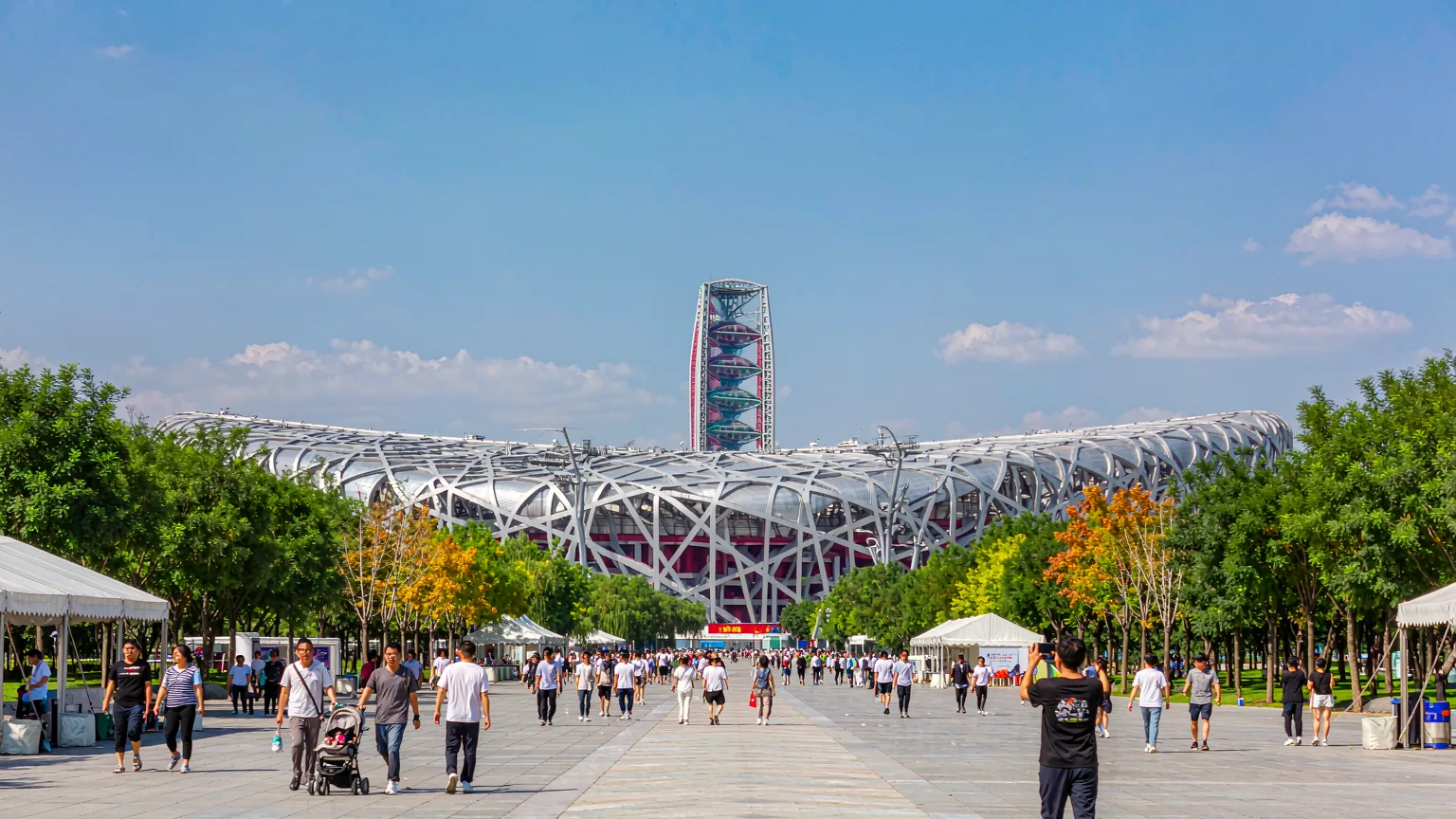 Visitors strolling the central axis toward Bird's Nest stadium