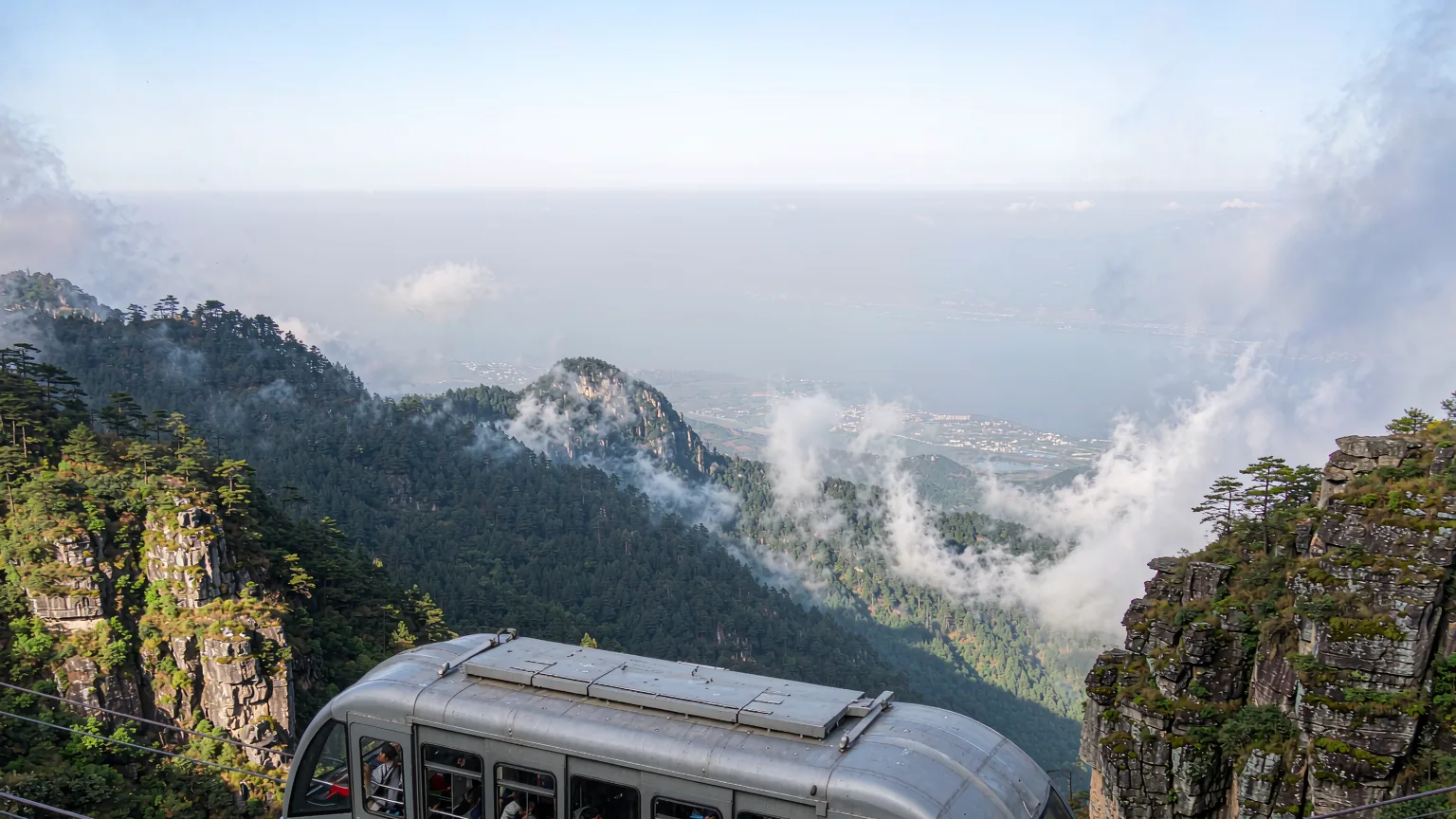 Cable car rising through clouds on Cangshan with Erhai Lake below