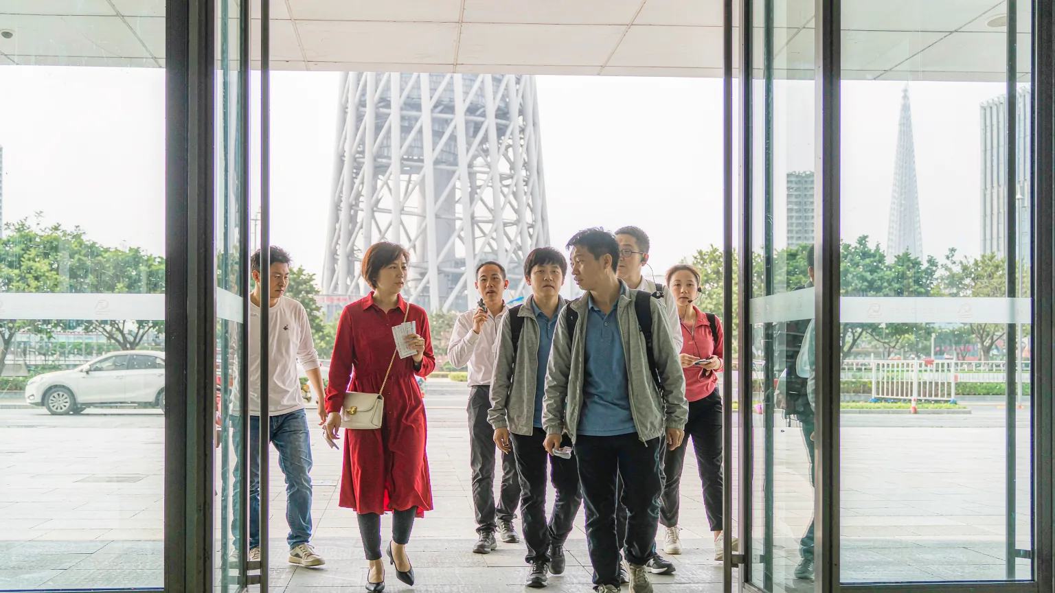 Tourists entering Canton Tower's modern glass entrance hall with guide
