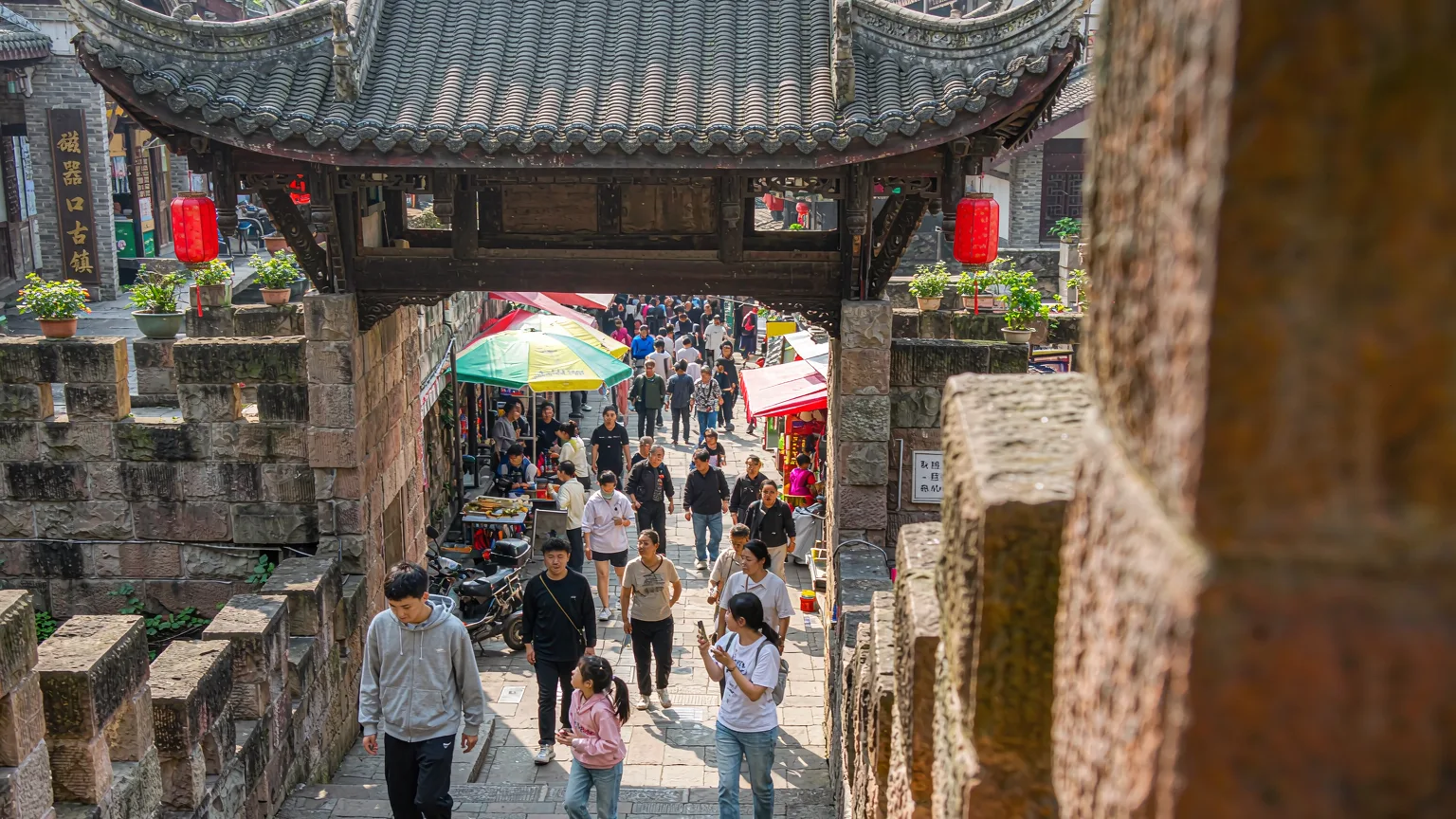 Tourist walking through the entrance archway of Ciqikou Ancient Town