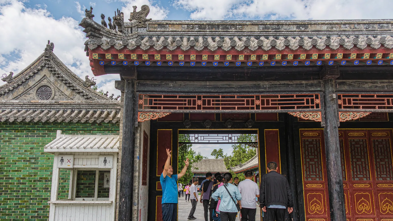 Visitors entering the Confucius Mansion with a guide, main gate in view