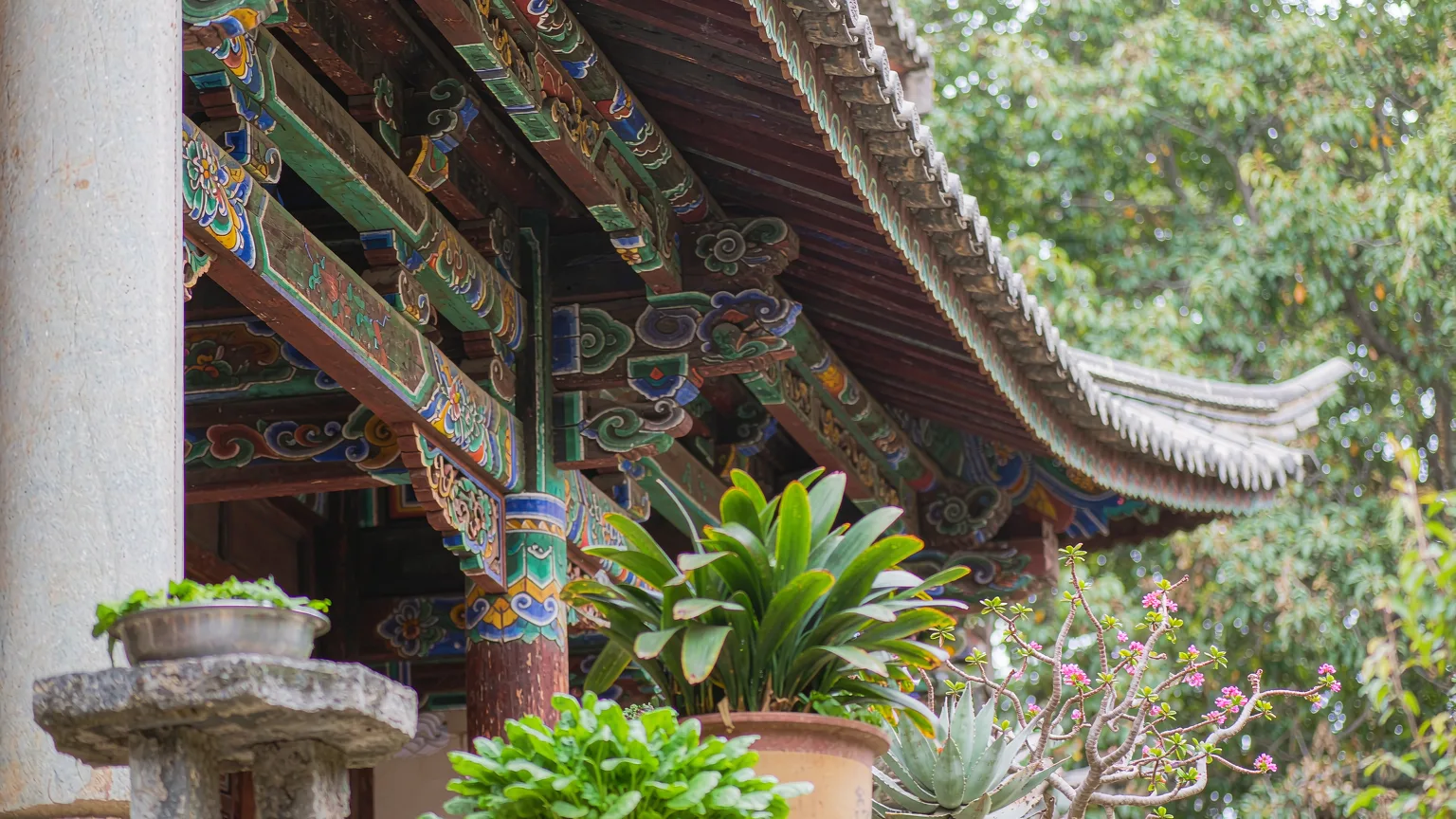 Close-up of intricate wooden carvings on Bai courtyard eaves in Dali