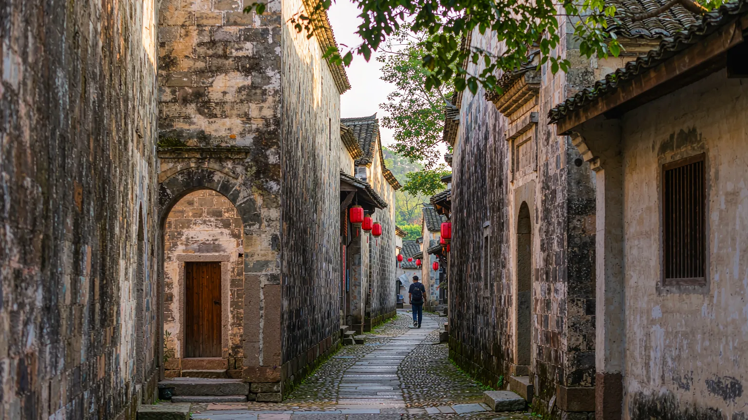 Narrow stone lane inside Dapeng Fortress with traditional houses and red lanterns
