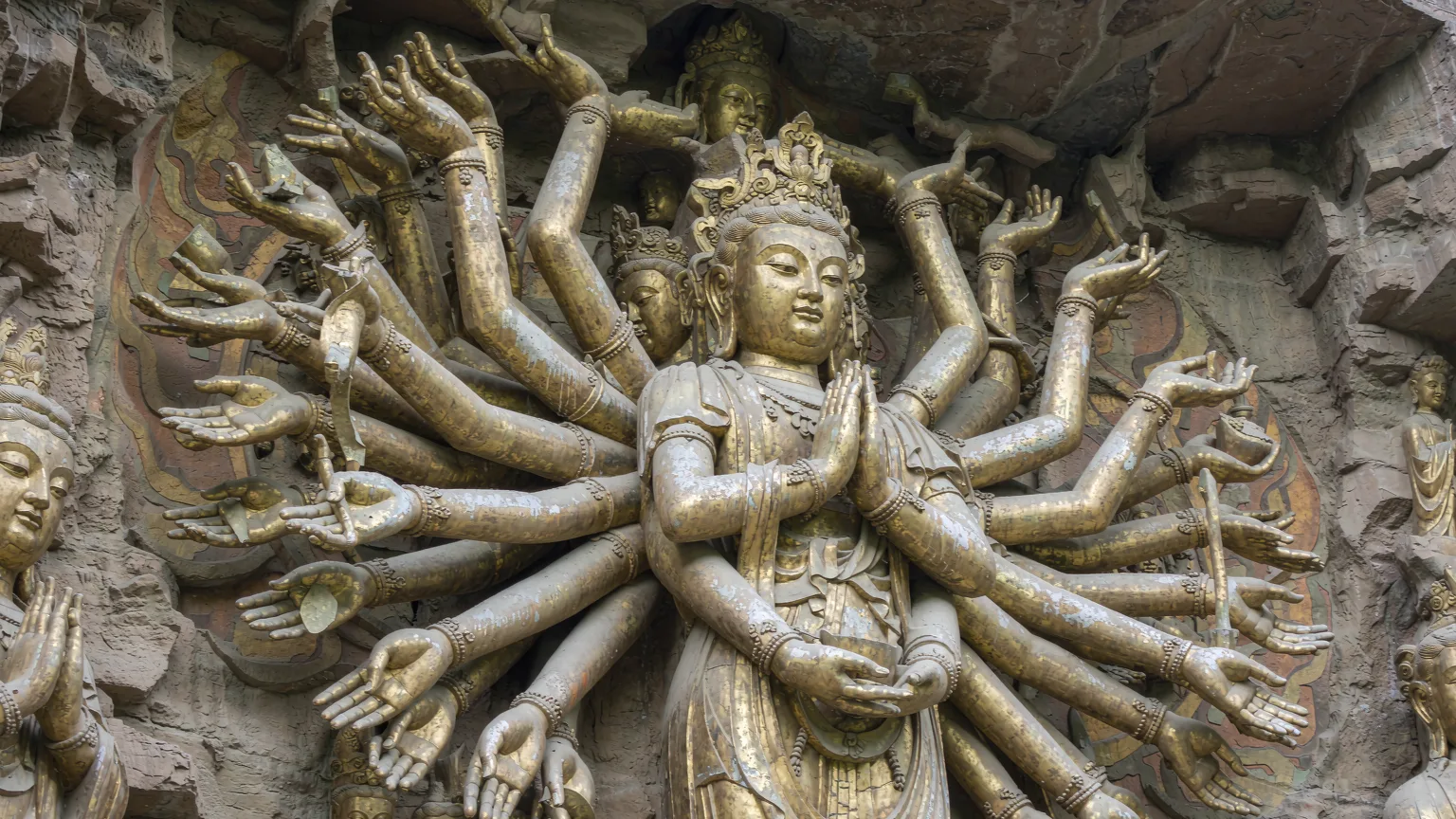 Thousand-Hand Guanyin carving with golden hands at Dazu Rock Carvings.