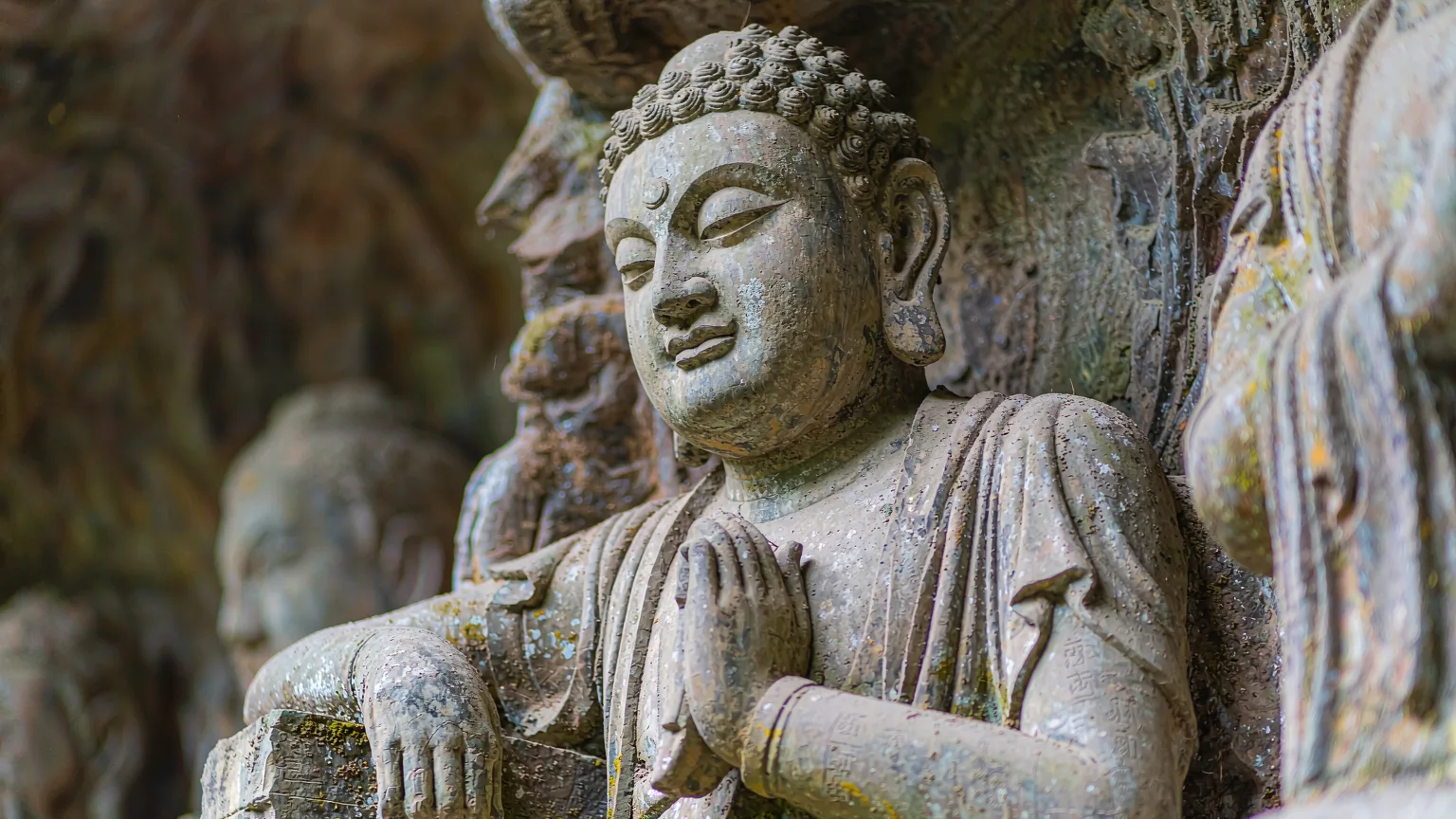 Close-up of a weathered Buddhist disciple carving at Beishan, Dazu.