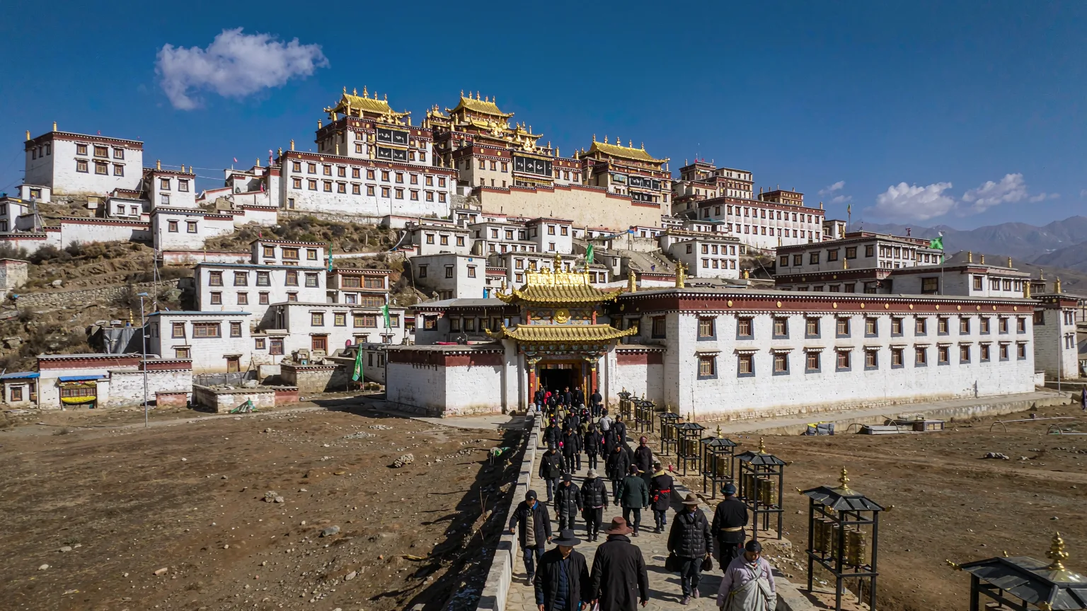Pilgrims climbing stone steps to the entrance of Drepung Monastery