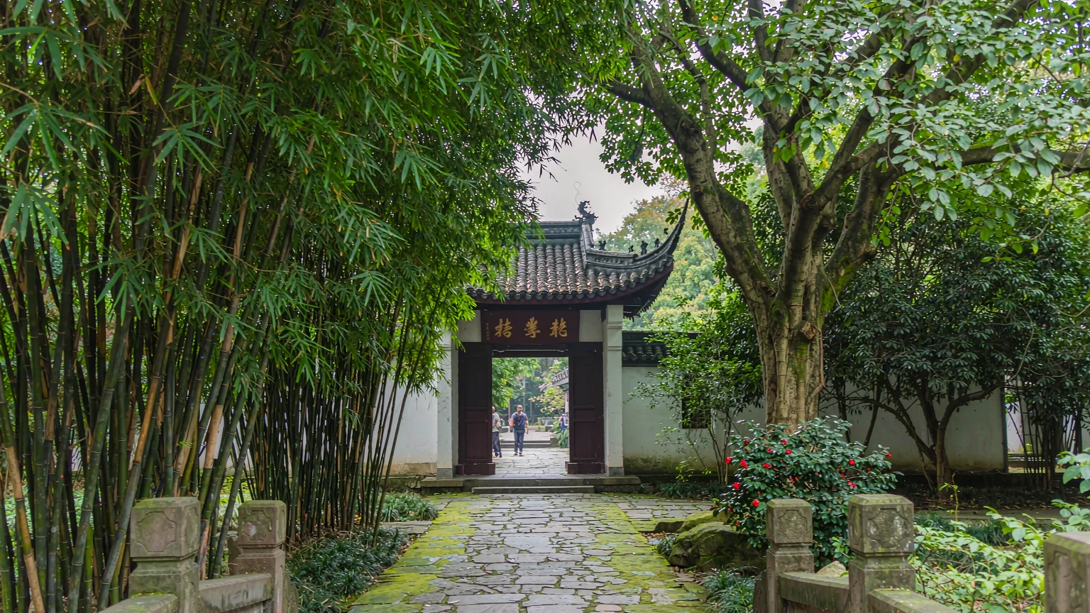 Stone pathway leading to the entrance of Du Fu Thatched Cottage with bamboo