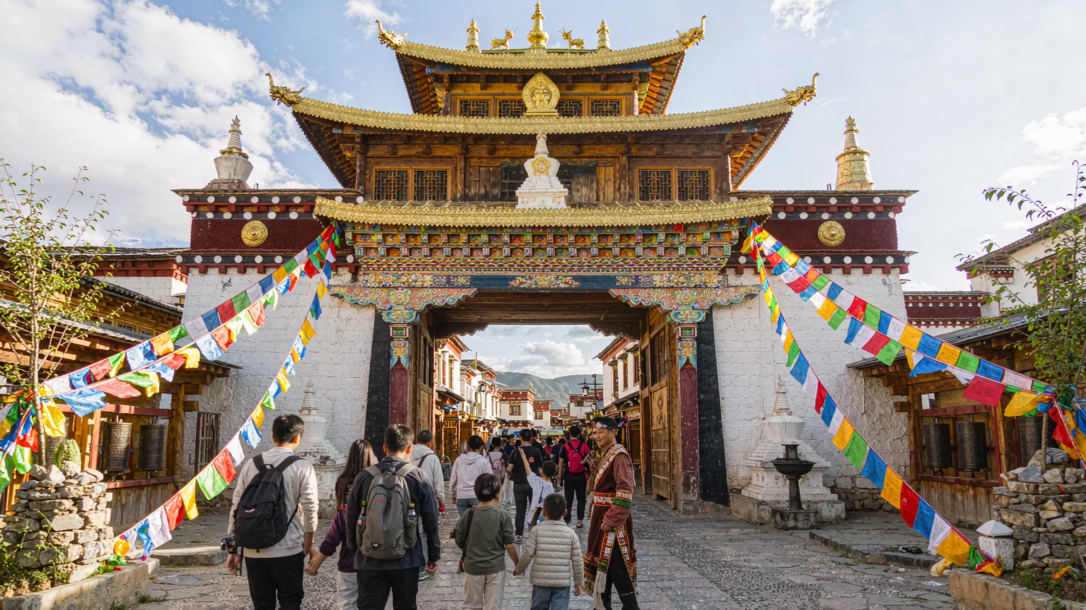 Tourists entering Dukezong Ancient Town through a traditional Tibetan gate