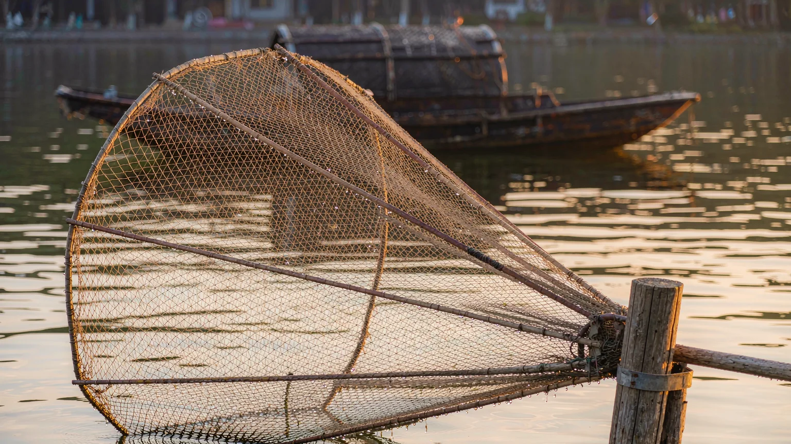 Close-up of traditional fishing net and wooden boat on Erhai Lake