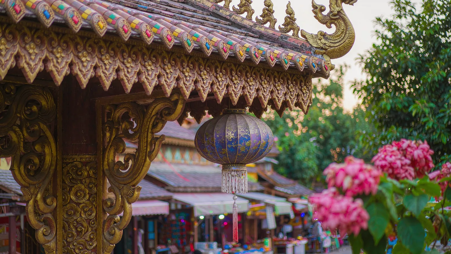 Close-up of ornate Dai wood carving and lantern at Gaozhuang Xishuangjing