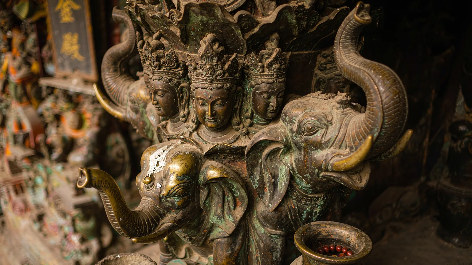 Close-up of bronze Samantabhadra statue details with prayer offerings at Golden Summit Mount Emei