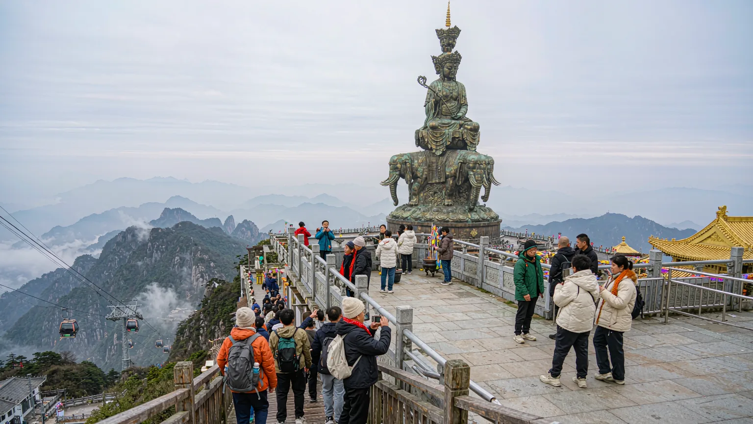 Visitors arriving by cable car at Golden Summit platform with Samantabhadra statue on Mount Emei