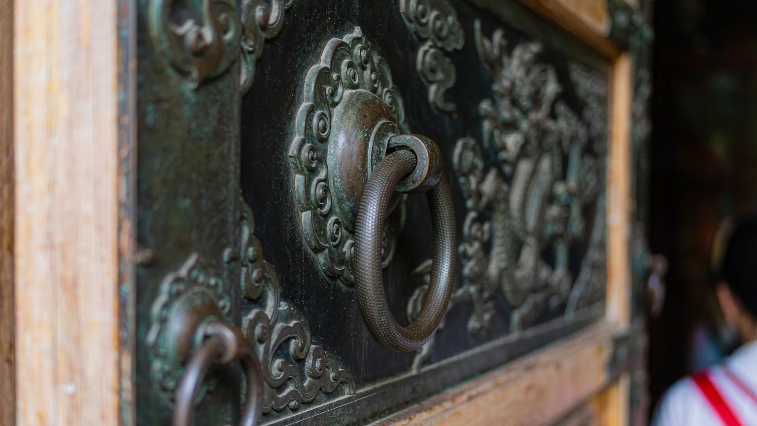 Close-up of patinated bronze door panel with dragon relief, Golden Temple