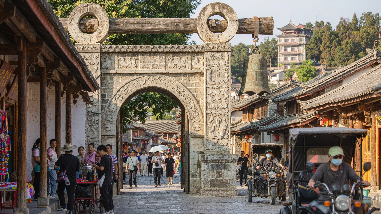 Tourists entering Guandu Ancient Town through traditional archway