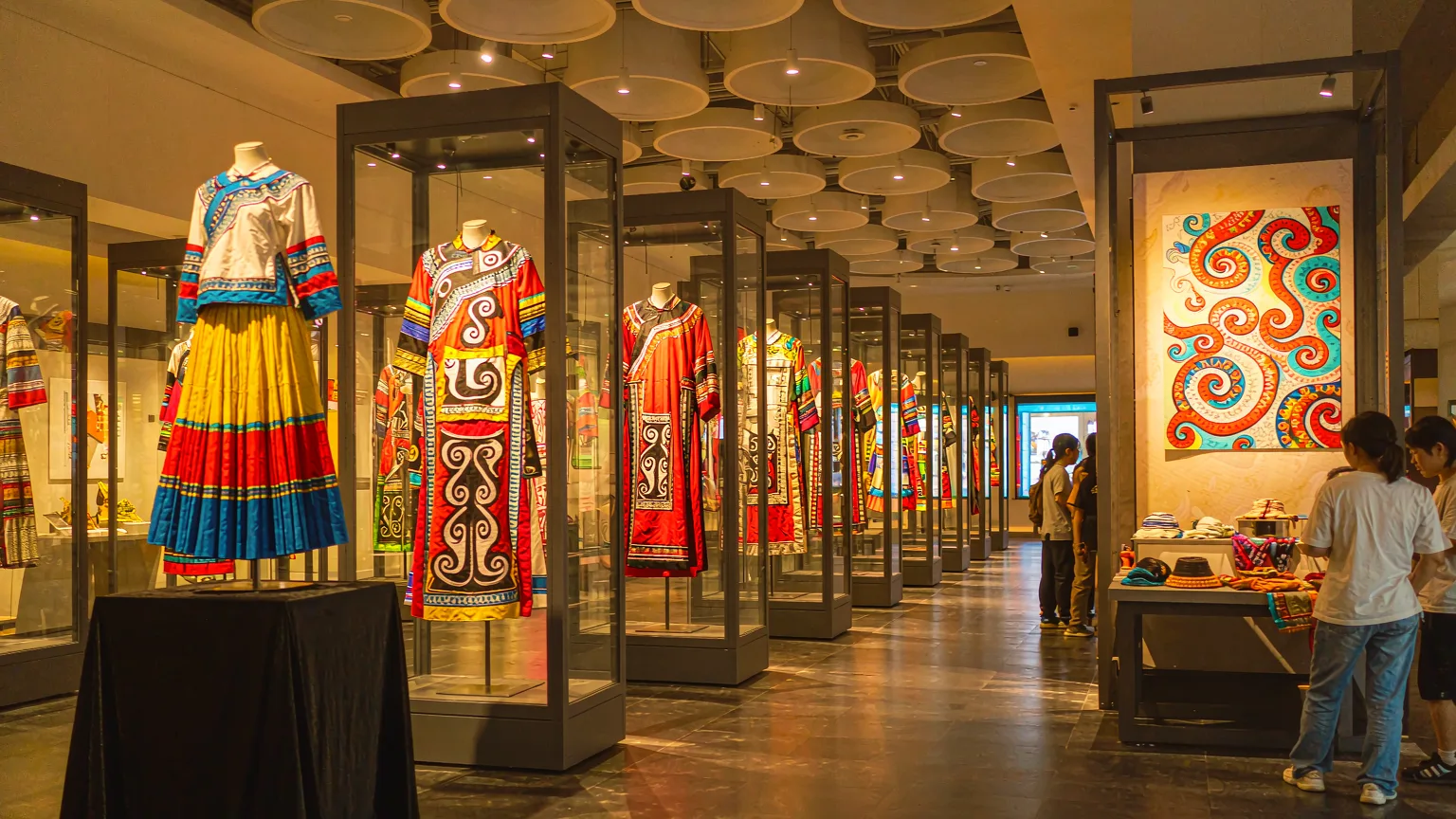 Colorful ethnic costumes and textiles displayed in museum gallery