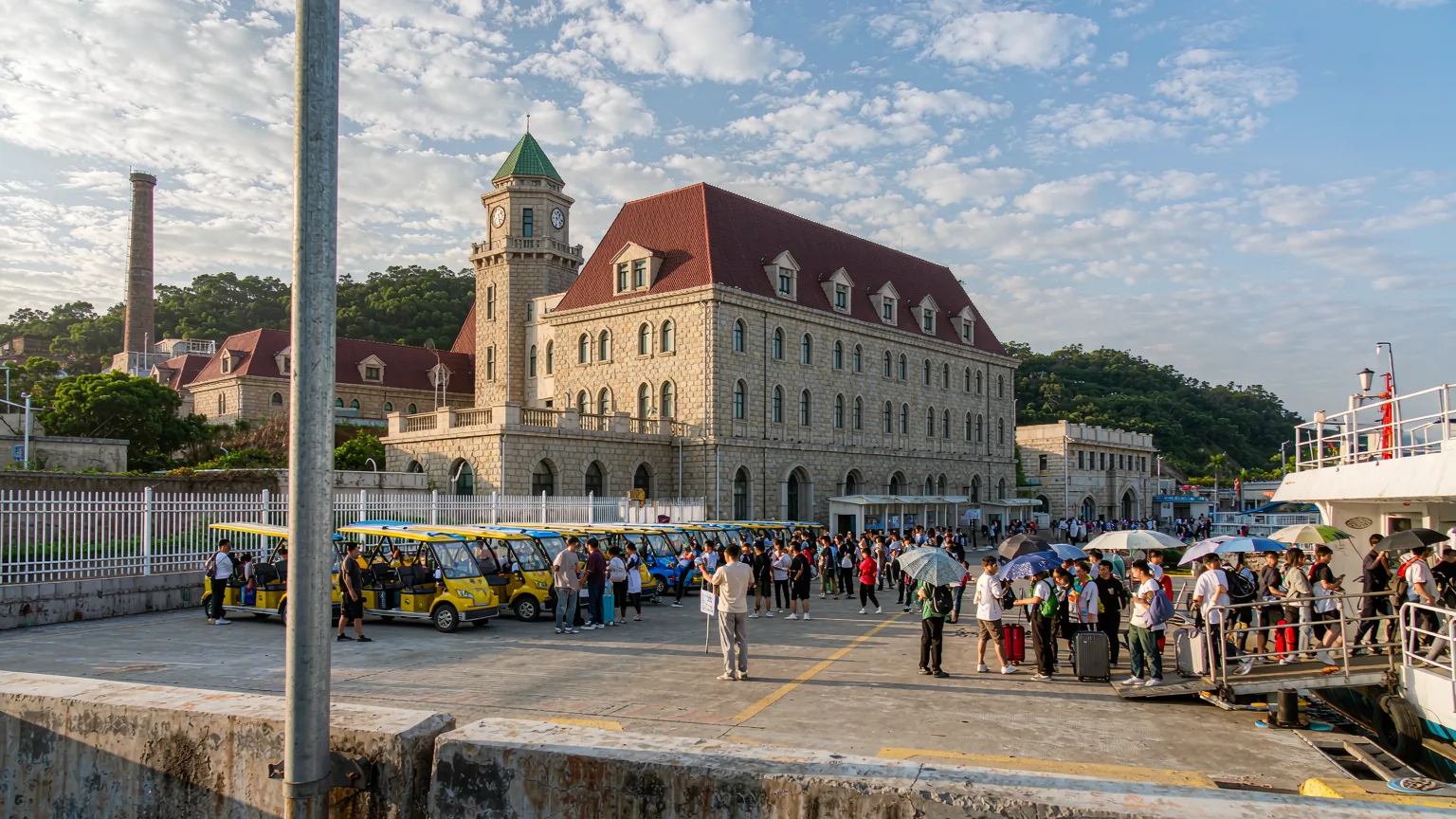 Visitors arriving by ferry at Gulangyu Island pier with electric buggies