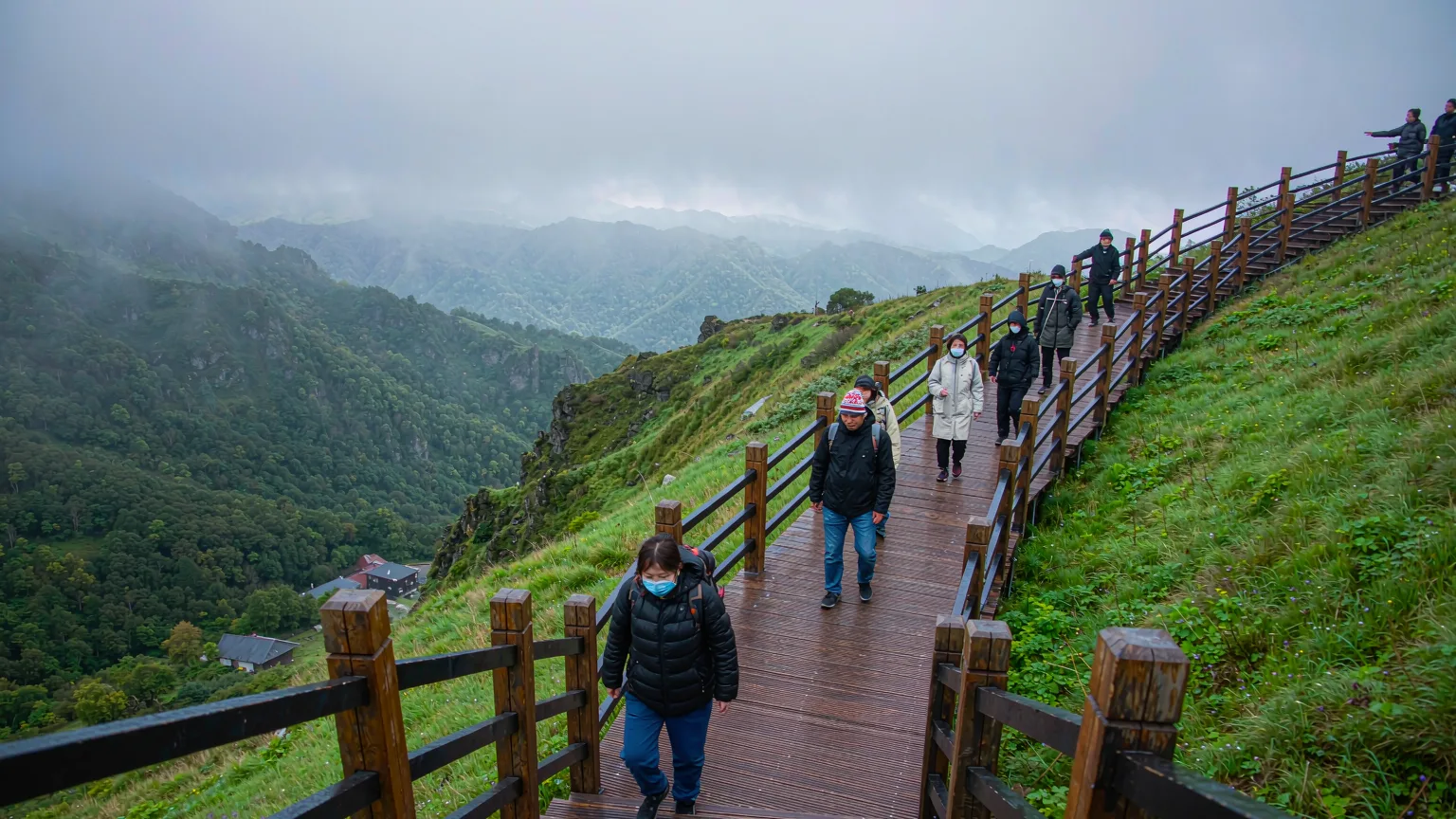 Tourists on wooden boardwalk approaching Heaven Lake viewpoint