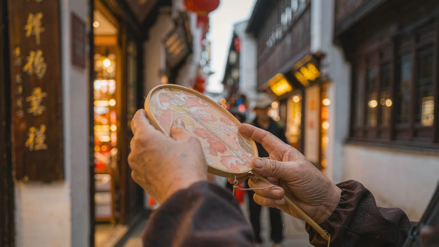 Craftsman shaping a traditional silk fan on Hefang Street