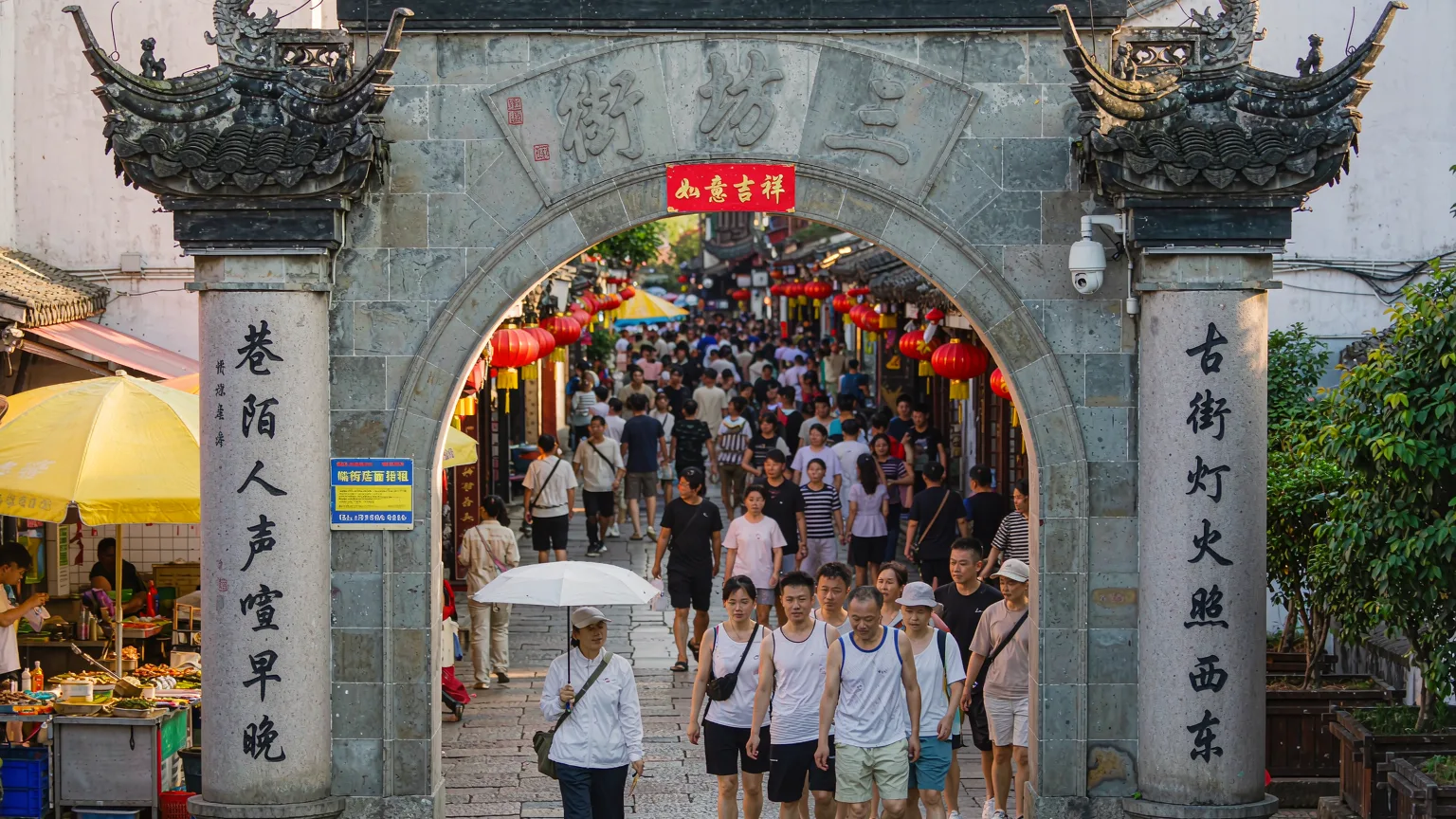 Visitors entering Hefang Street through a traditional archway