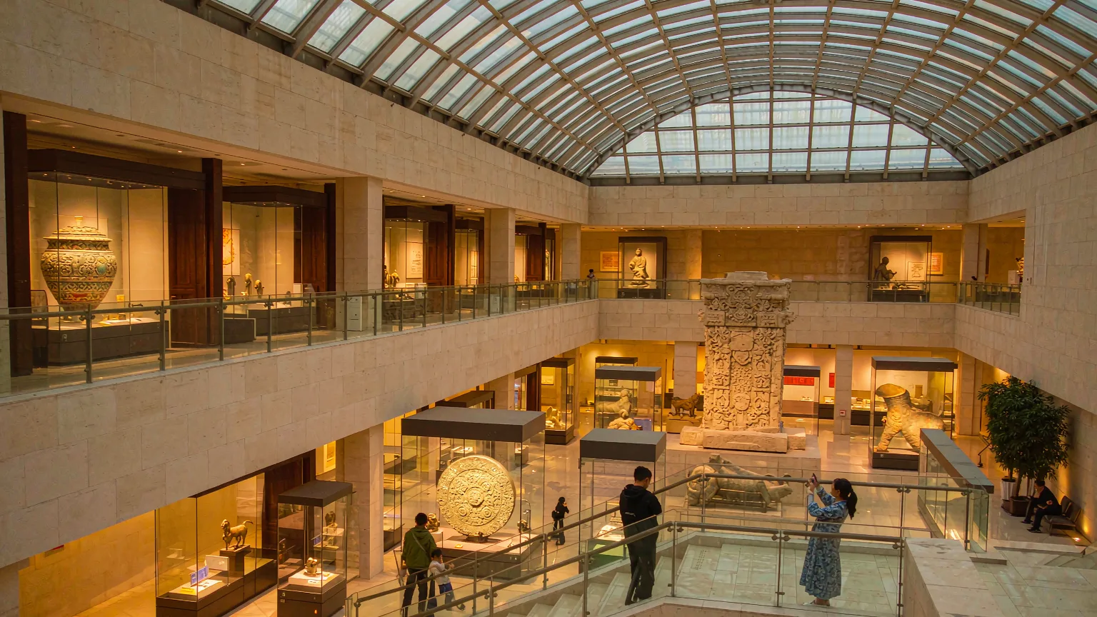 Grand atrium of Henan Museum with glass roof and visitors viewing artifacts
