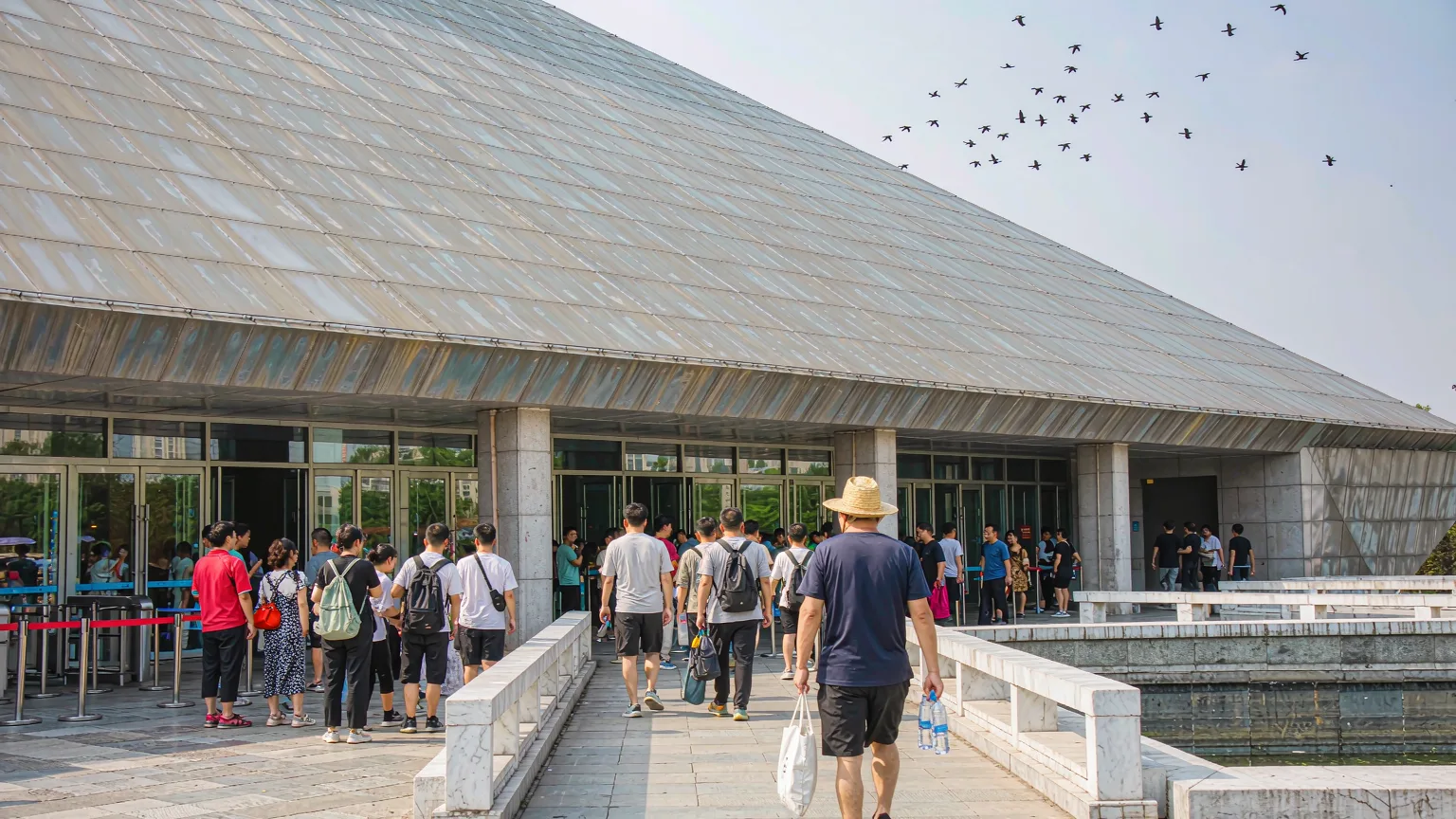 Visitors entering Henan Museum through main entrance with pyramid architecture above