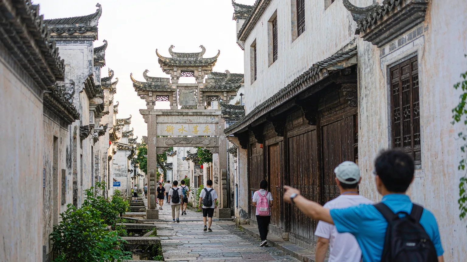 Tourists walking through a narrow lane in Hongcun with a guide