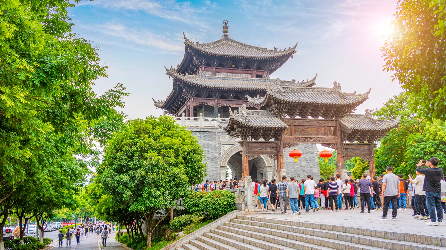 Tourists climbing stone steps to Hongshan Park's entrance gate