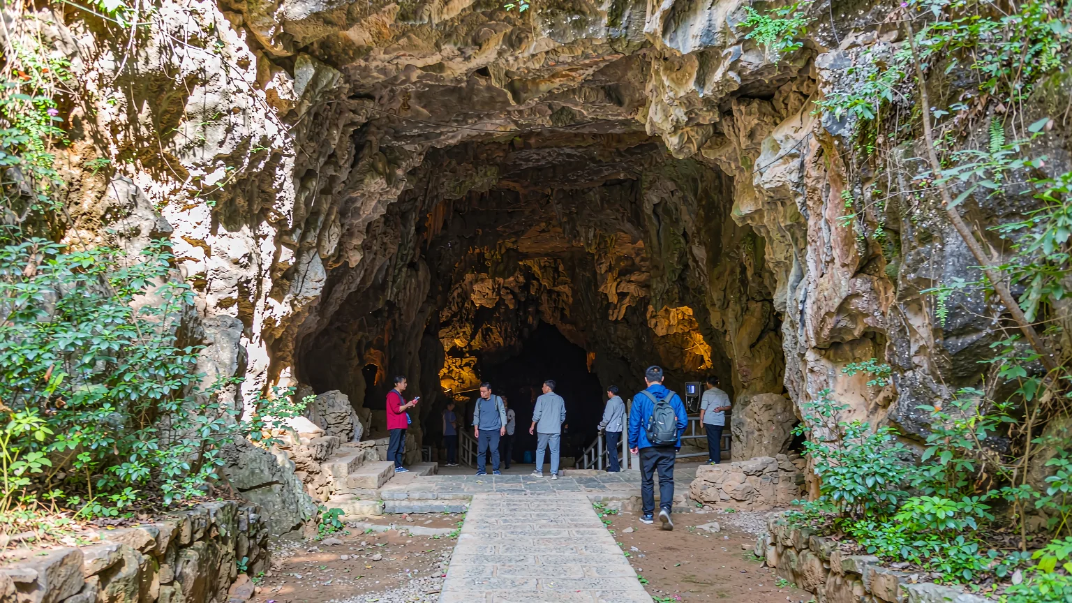 Visitors walking along the entrance path into Huanglong Cave
