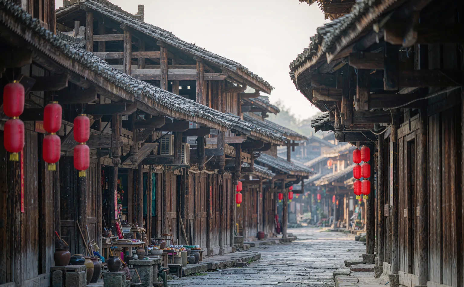 Traditional wooden houses and red lanterns on the flagstone street of Huanglongxi Ancient Town