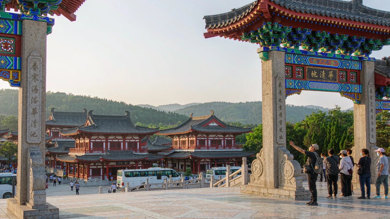 Tour group entering Huaqing Palace through traditional gate with guide