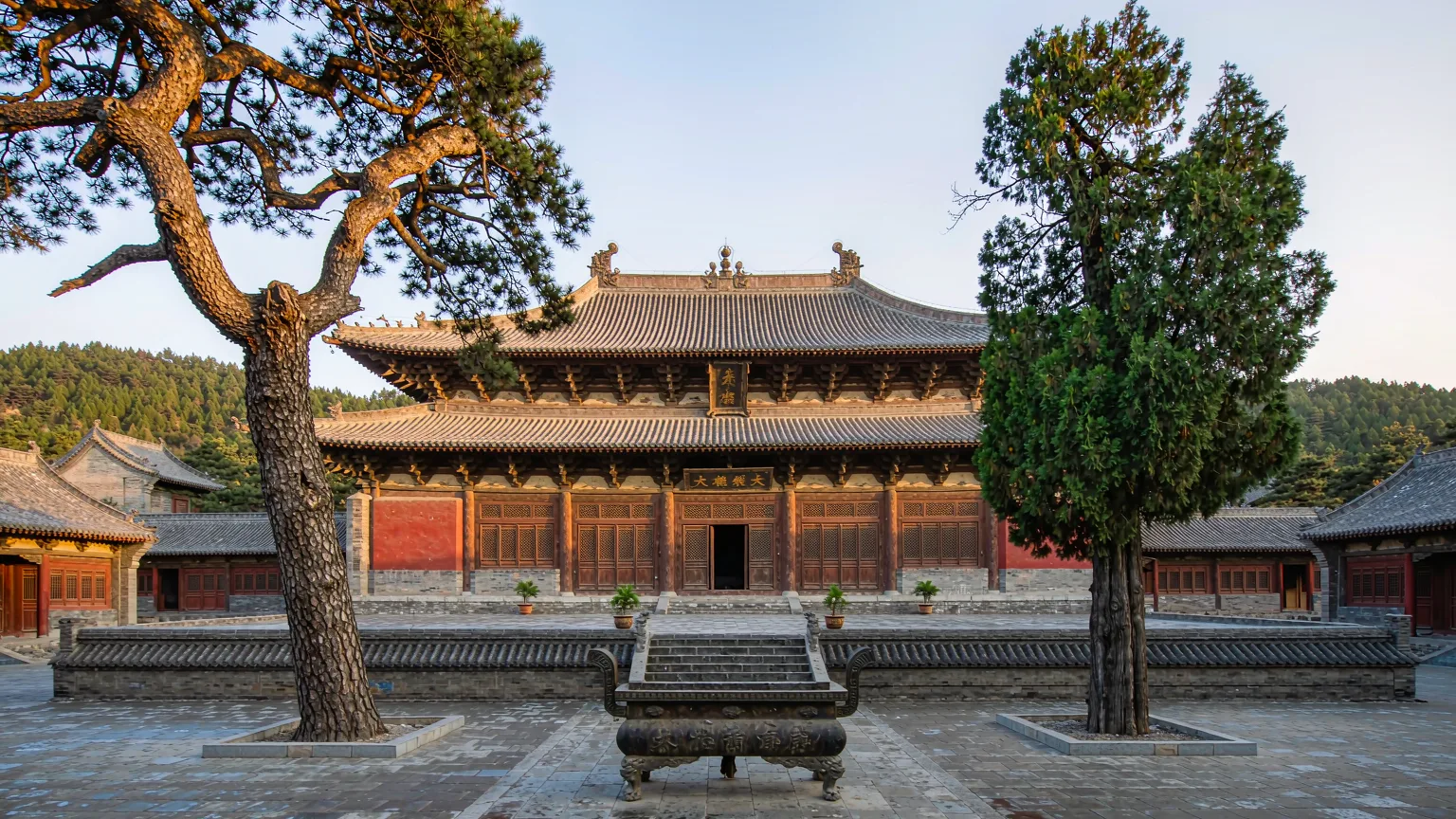 Symmetrical courtyard of Huayan Temple's upper monastery with ancient trees and incense burner