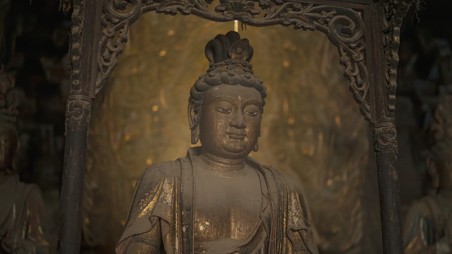 Close-up of a serene sculpted wooden bodhisattva inside Huayan Temple