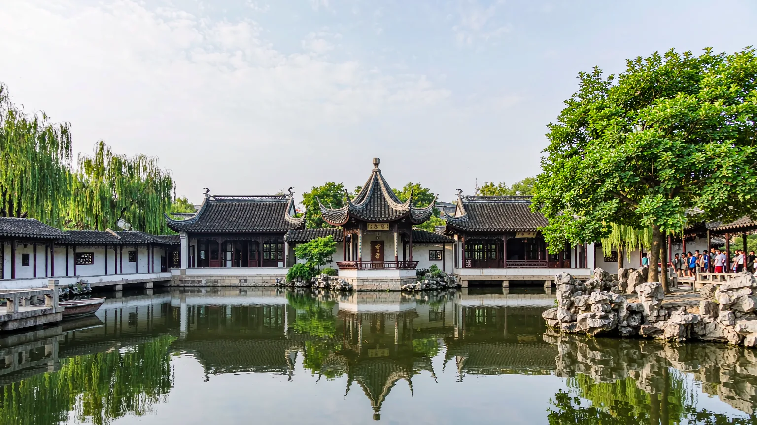 Central pond reflecting pavilions and willow trees in Humble Administrator's Garden.