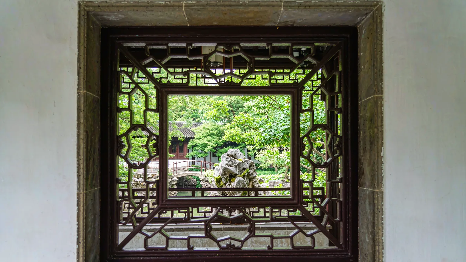 Intricate lattice window with garden view in Humble Administrator's Garden.