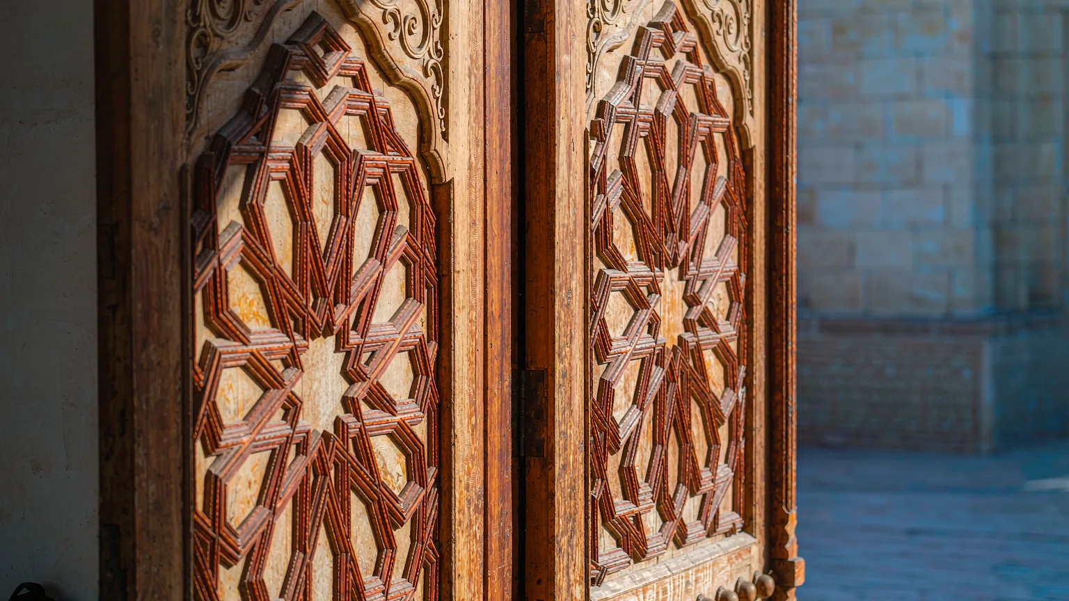 Close-up of intricate wooden carvings on Id Kah Mosque's doors