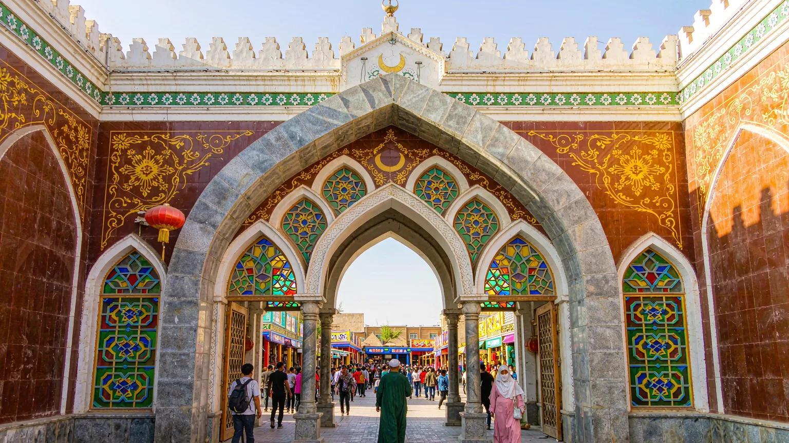 Visitors entering Id Kah Mosque through its grand archway in Kashgar