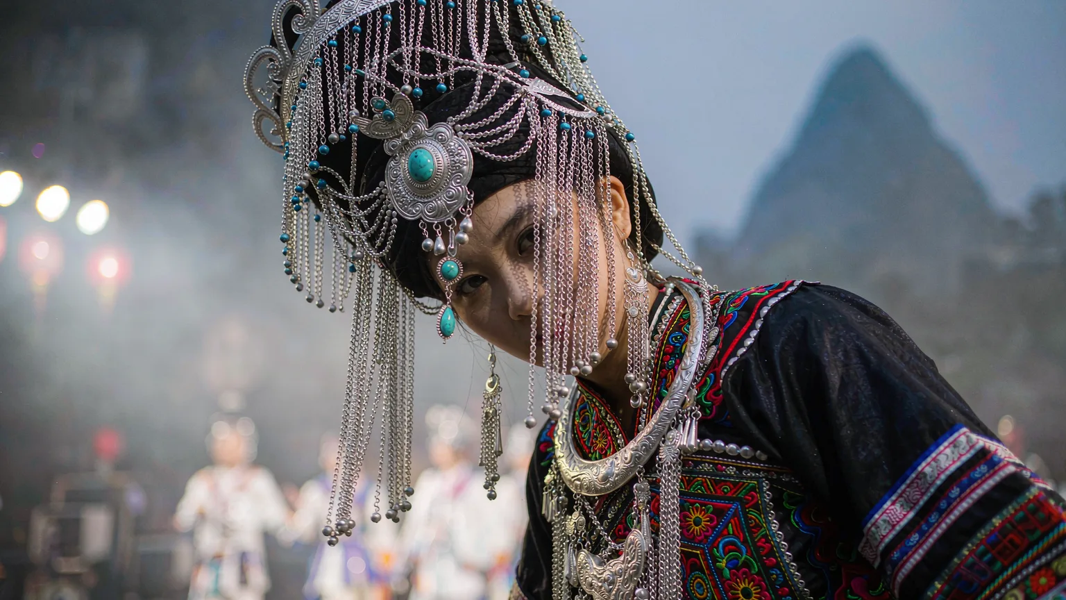 Close-up of performer's silver headdress and embroidered Zhuang costume