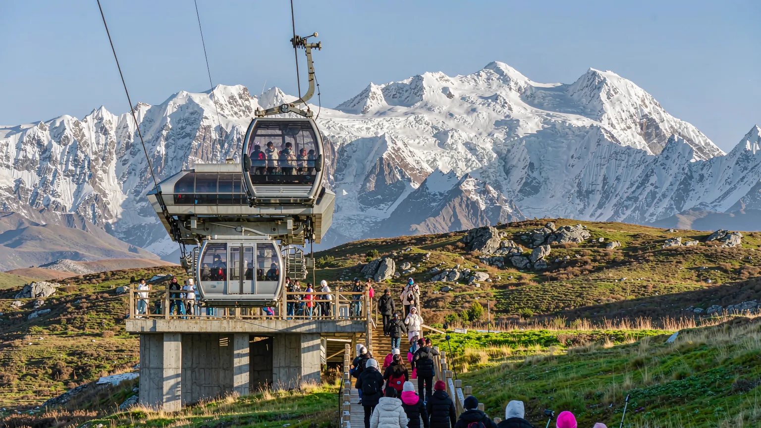Tourists boarding cable car to ascend Jade Dragon Snow Mountain from Ganhaizi Meadow