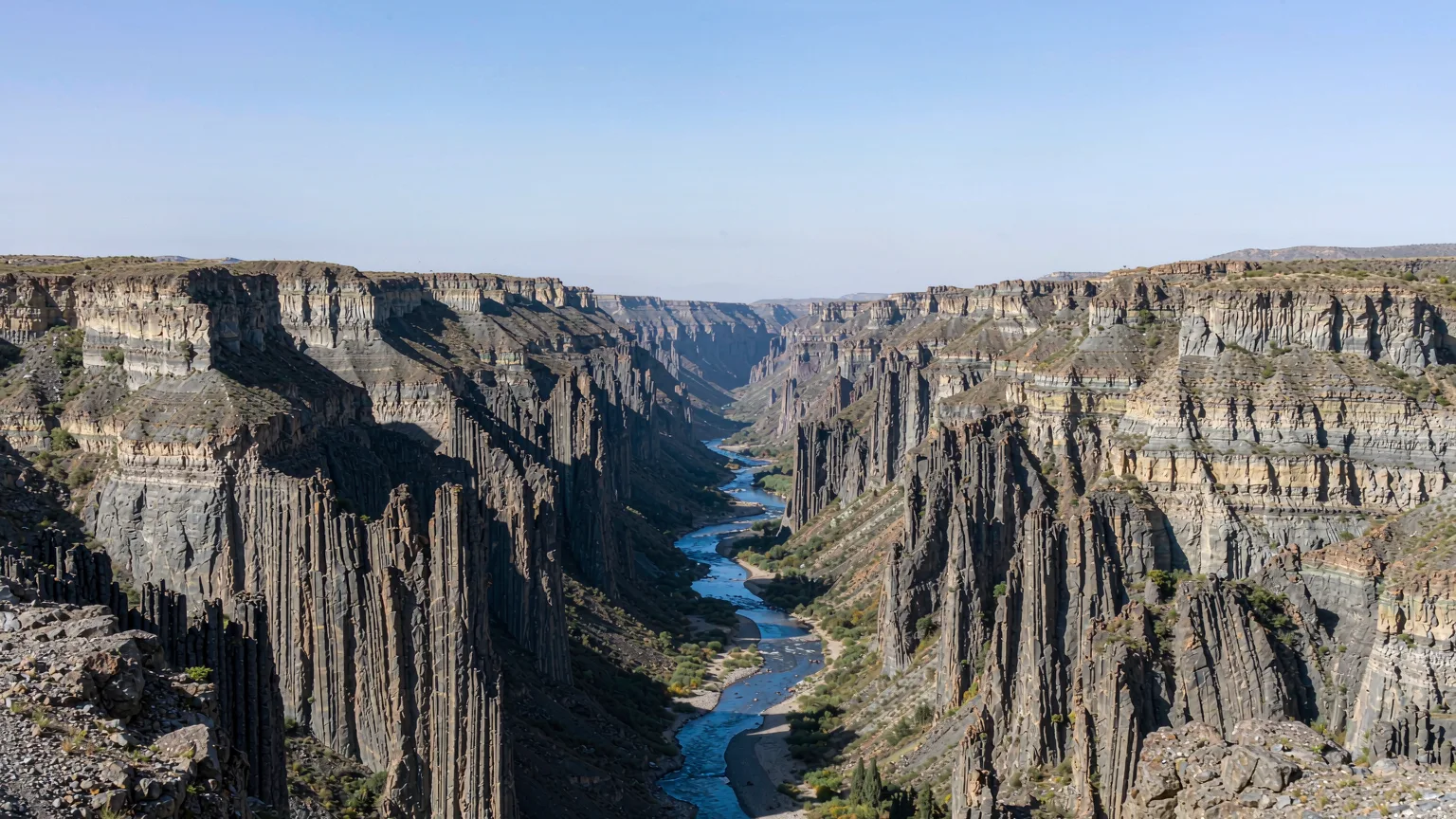 Panoramic view of Jinjiang Grand Canyon's layered volcanic walls and winding river