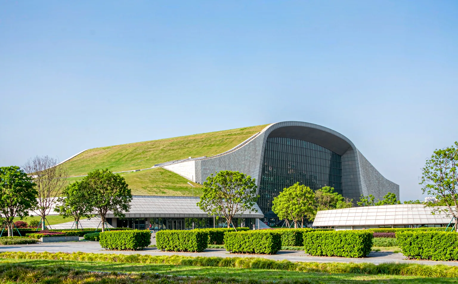 The grass-roofed Jinsha Site Museum building surrounded by park greenery