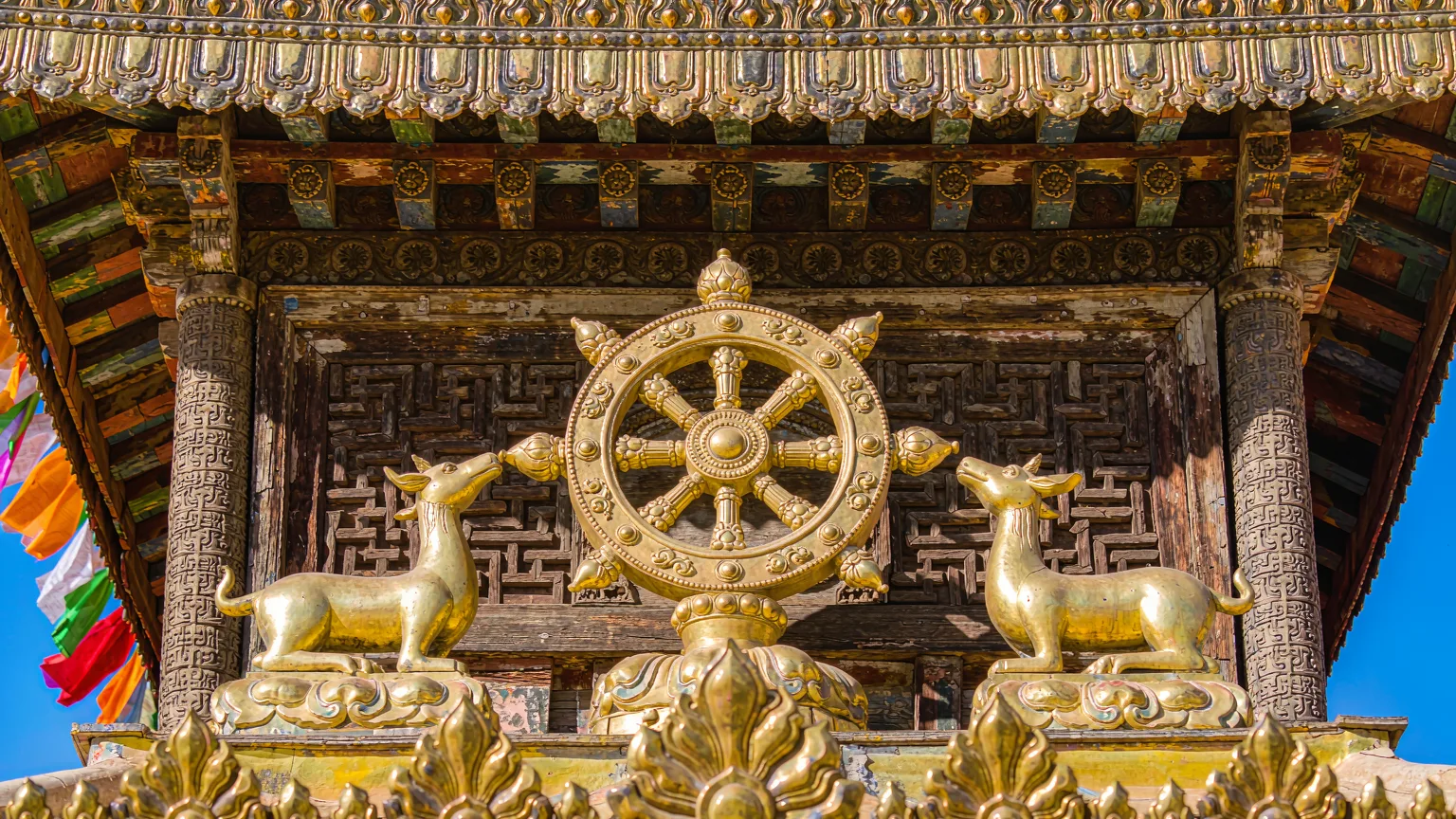 Golden dharma wheel and deer detail on Jokhang Temple rooftop