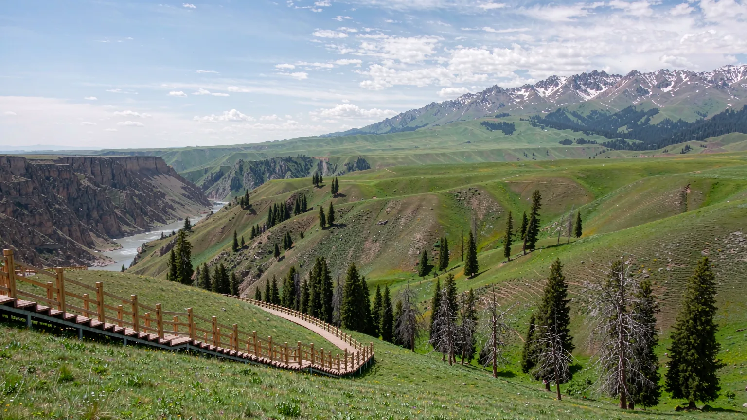 Tourists on boardwalk trail in Kalajun Grassland with canyon view