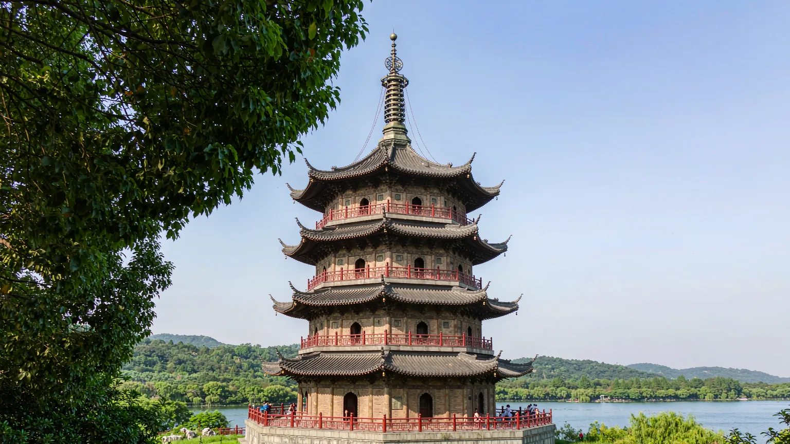 Leifeng Pagoda's five-tiered tower rising among trees above West Lake