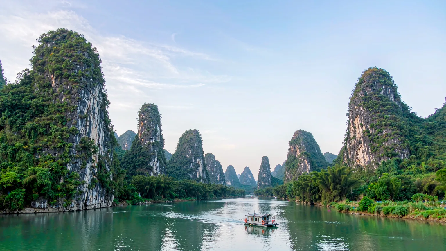 Panoramic Li River scene with limestone cliffs and a cruise boat