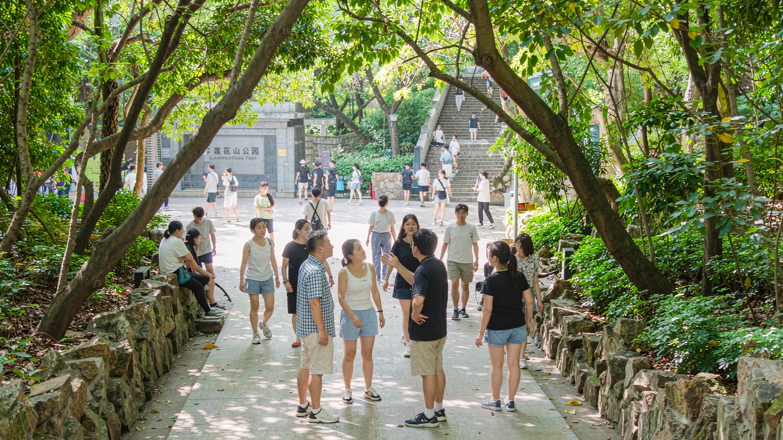 Visitors walking a shaded trail toward Lianhuashan Park summit