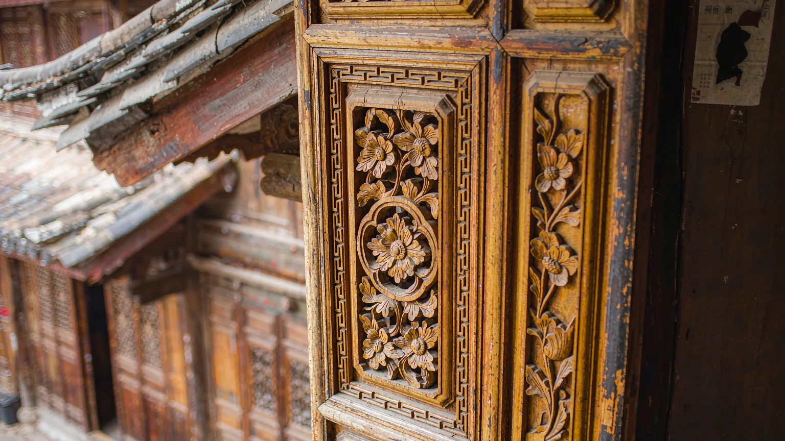 Detailed Naxi wooden carvings on a door in Lijiang Old Town