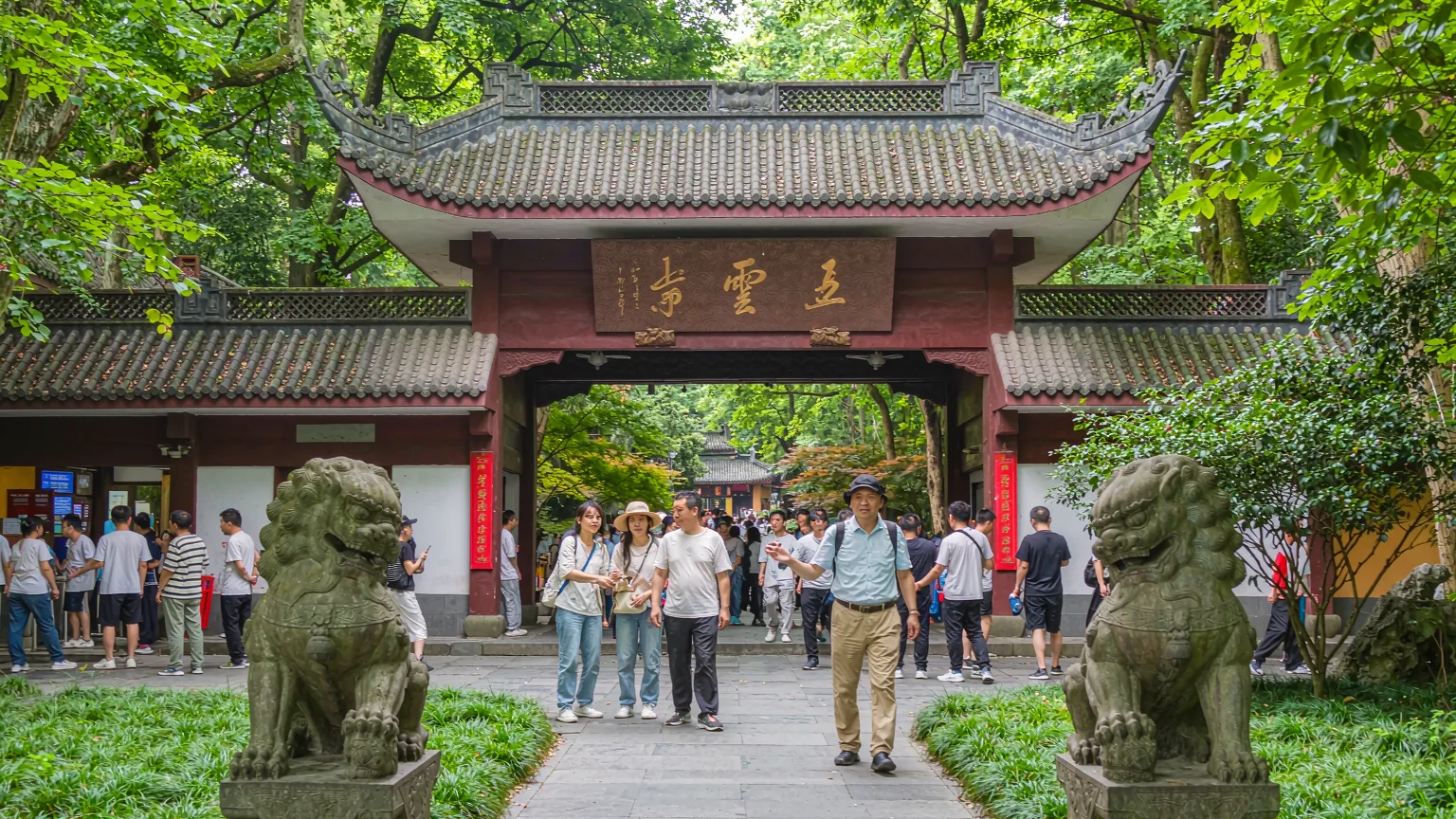 Entrance gate of Lingyin Temple with visitors and guide