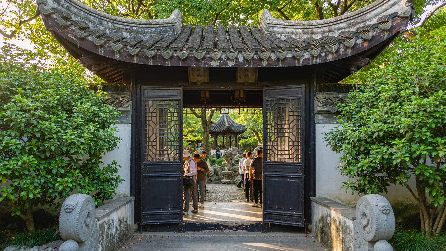Visitors entering Lion Grove Garden through traditional Chinese gate in Suzhou